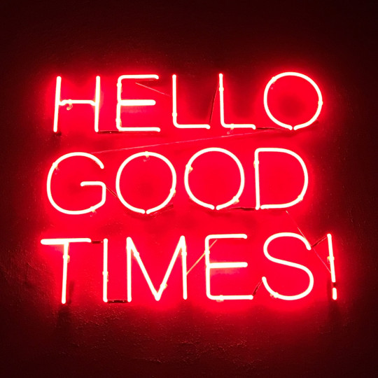 A neon sign reading "Hello Good Times!"