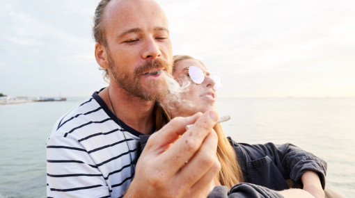 A happy couple sharing a joint in nature