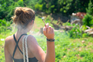 A young woman with a cannabis cigarette