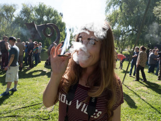 young woman taking a hit of cannabis
