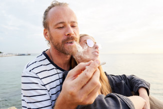 A happy couple sharing a joint in nature