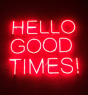 A neon sign reading "Hello Good Times!"